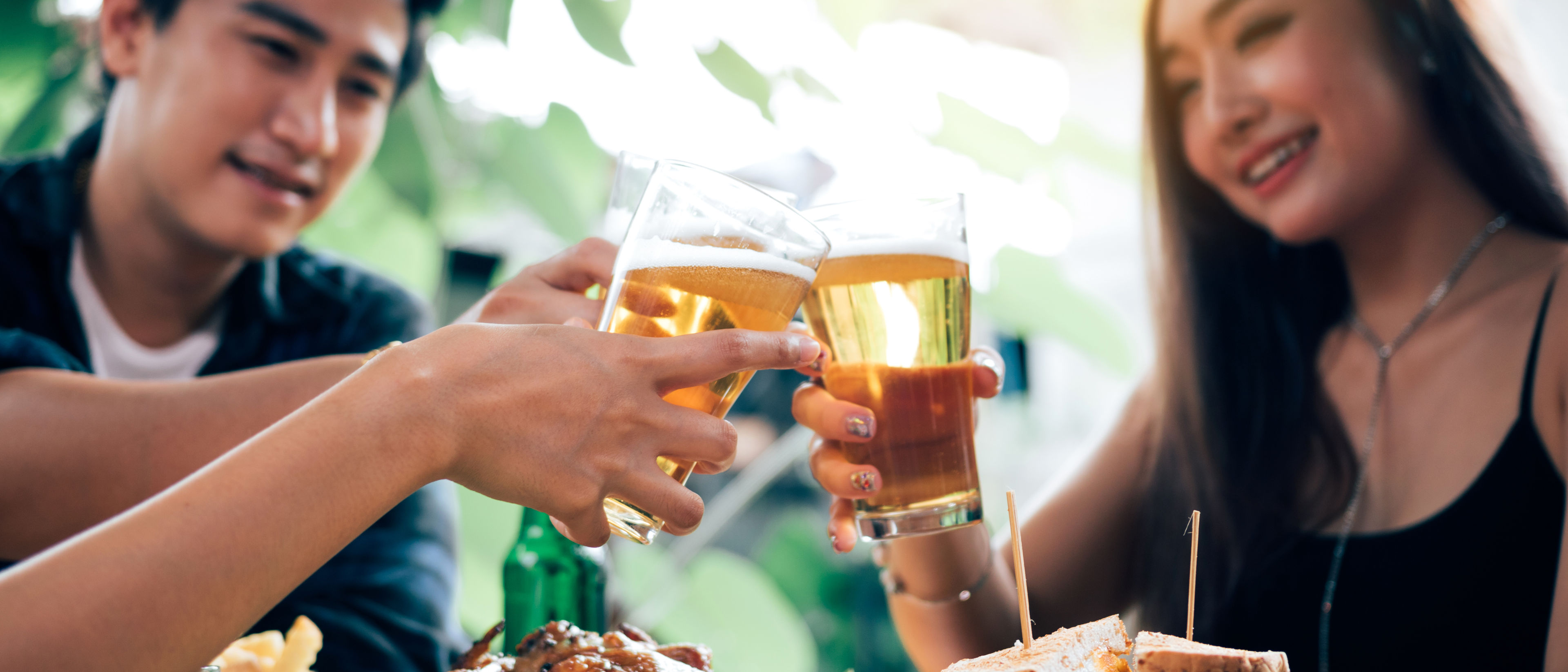 Group of asian people cheering beer at restaurant.