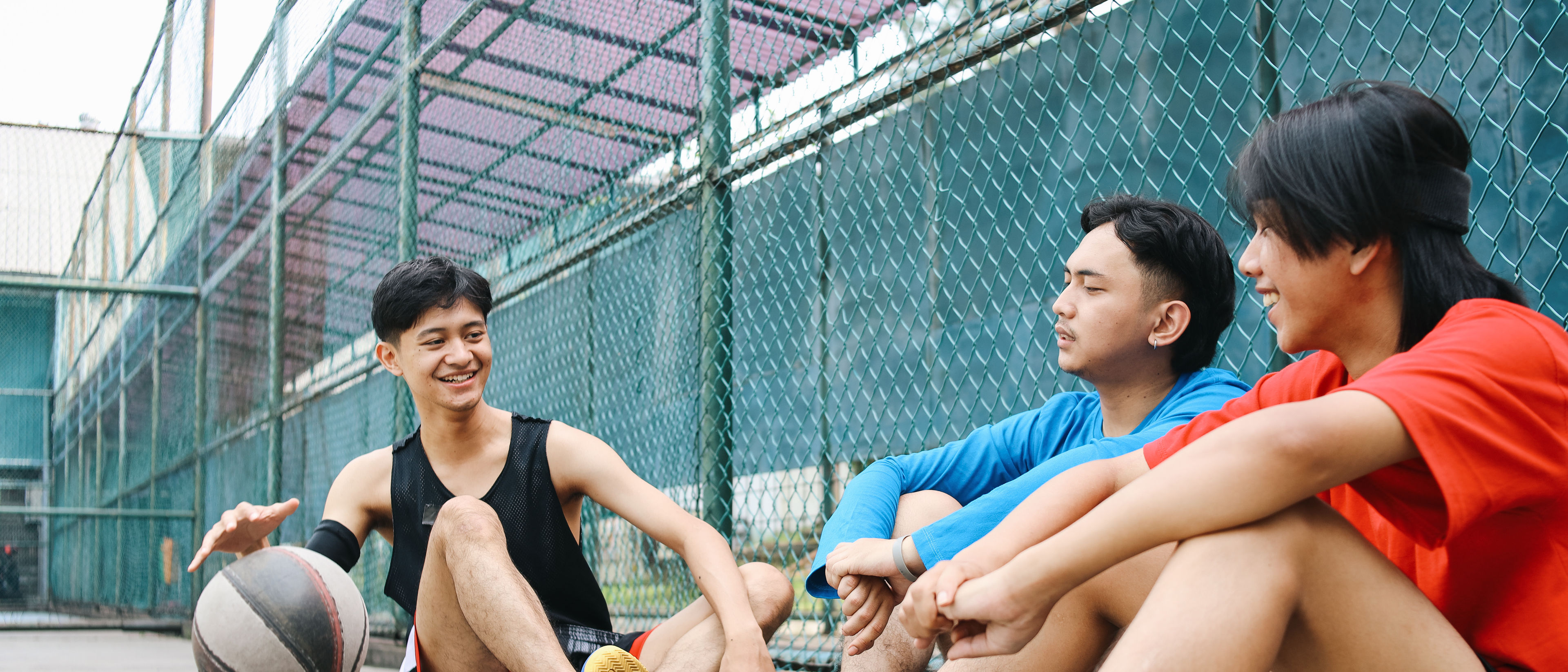 Friends resting after playing basketball.